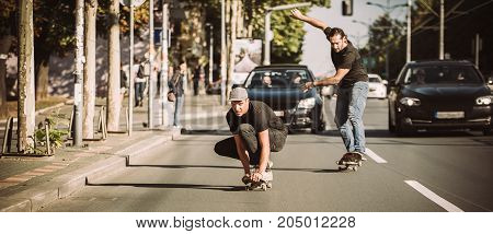 Two Skateboarders Riding Skateboard Slope On The City Streets