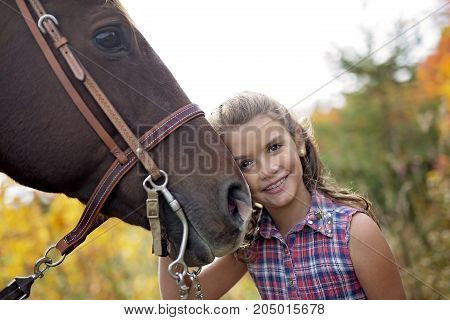 in a beautiful Autumn season of a young girl and horse in a field