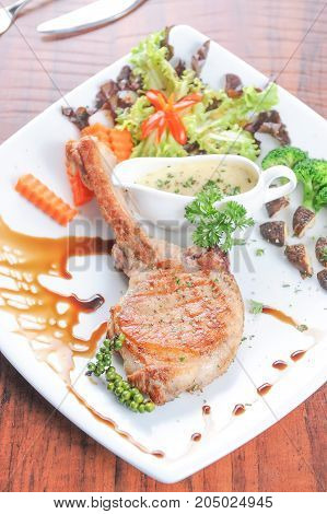 Grilled pork steak and vegetables on plate