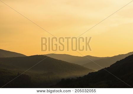 Orange sunset in forest mountains. Carpathians Ukraine