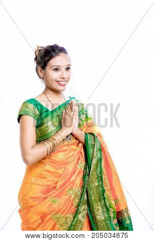 Happy young beautiful traditional Indian woman in traditional saree, Welcome Posing