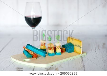 Wine glass and wood tray with cheeses