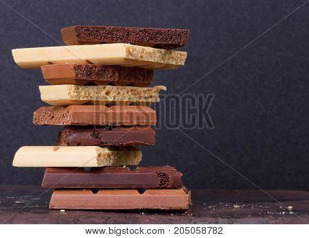 stack of different kind porous chocolate pieces on a dark background.