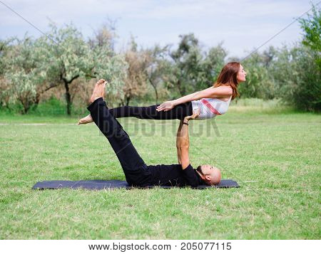Photo of practicing yoga outdoor. Doing yoga fitness. Exercise for relax and healthy body.