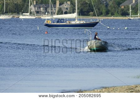 Mattapoisett Massachusetts USA - May 29 2007: Small powerboat skimming toward mouth of Mattapoisett River