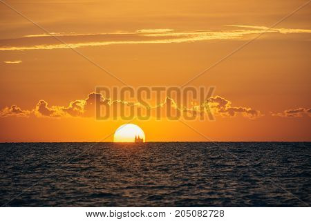 Albania. Golem. Sunset on the Adriatic Sea with the silhouette of the ship on the horizon