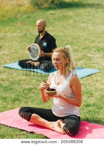 People at the health club outside with personal trainer, learning the correct form.