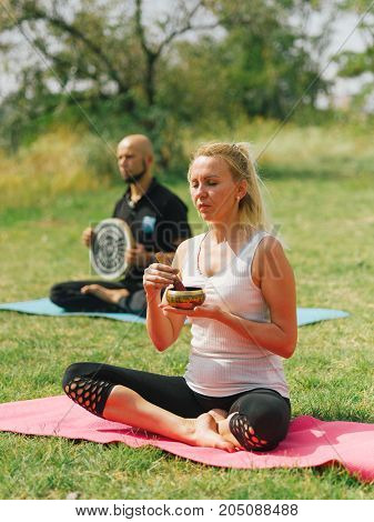 People at the health club outside with personal trainer, learning the correct form.