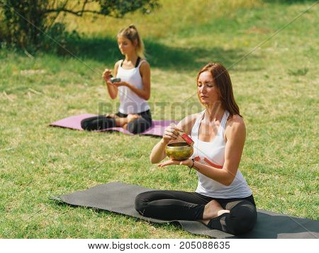 People at the health club outside with personal trainer, learning the correct form.
