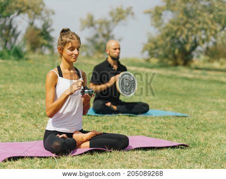 People at the health club outside with personal trainer, learning the correct form.