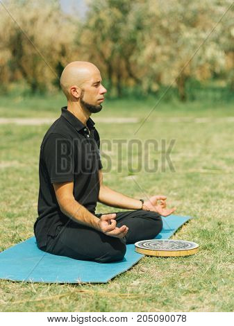 Athletic boy at the health club outside with personal trainer, learning the correct form.