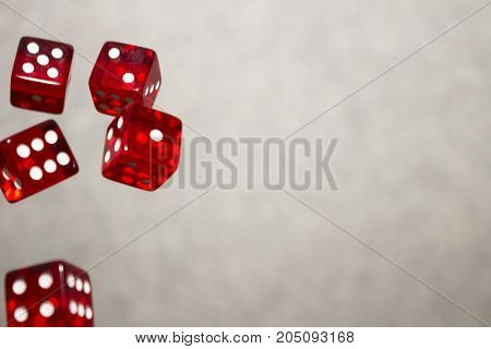 Several rolling red dice fall on a table with boardgame. Gameplay moments.