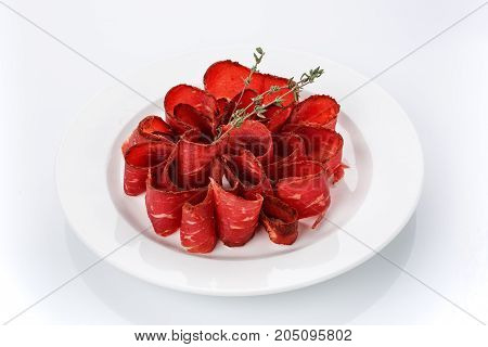 Snack for beer. Basturma on plate isolated on white background