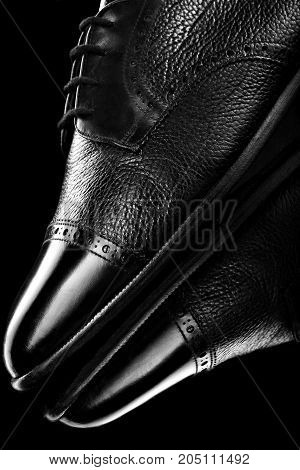Black oxford polished shoes on black miror background.Shoes shine. Close up.
