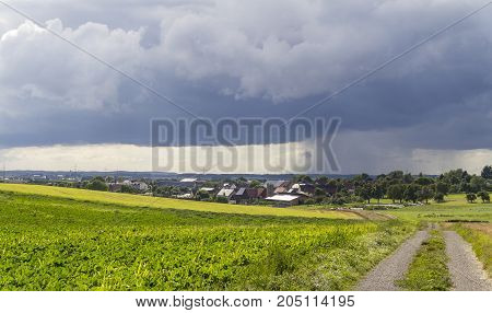 rainy scenery including a small village in rural agricultural ambiance