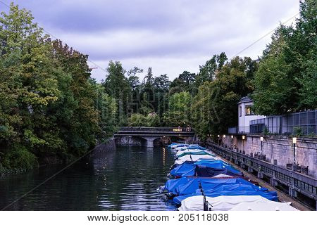 small boats in canal with tree and water reflection for fishing and sailing with raincovers at evening