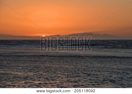 sunrise over the sea against the backdrop of the mountains