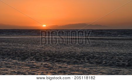 sunrise over the sea against the backdrop of the mountains
