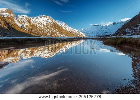 Snowed mountain reflection in the river in Pirineos