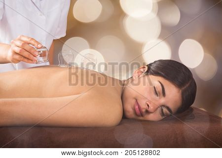 Close-up Of A Therapist Placing Transparent Glass Cups On Relaxed Young Woman's Back