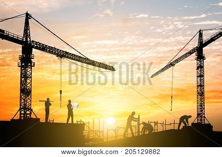 Silhouette Of Engineers Working At Construction Site During Sunset