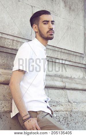 Street fashion concept. Portrait of elegant young handsome man. Paris buildings as background.