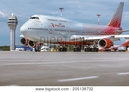Pulkovo, Saint-Petersburg, Russia - August 10, 2017:   The airplane Boeing 747 of Rossiya airlines is moving on the runway against the background of the ATC tower and blue cloud sky. Summer sunny weather