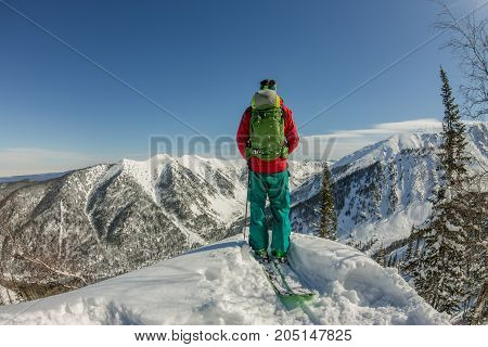 Man Standing At Top Of Ridge. Ski Touring In Mountains. Adventure Winter Freeride Extreme Sport