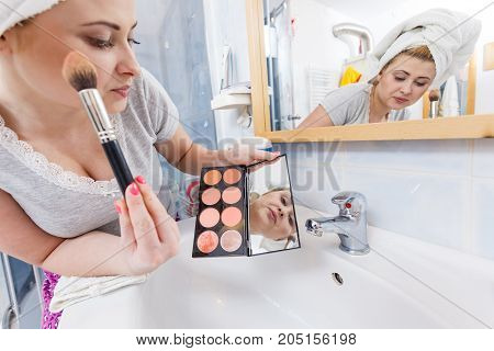 Woman In Bathroom Applying Contour Bronzer On Brush