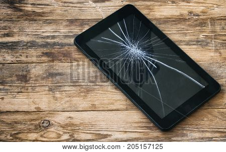 broken tablet computer cracked glass display before repair on wooden table top view