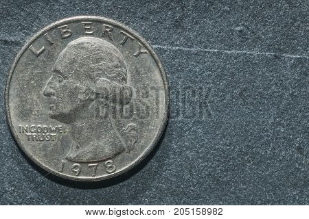 A quarter dollar coin on a grey background