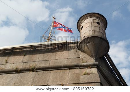 Flag and turret on Naryshkin bastion of Peter and Paul Fortress on a background cloudy sky in St-Petersburg, Russia