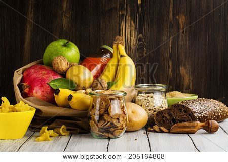 Assortment of products rich of complex carbohydrates. Healthy food on wooden background. Space for text
