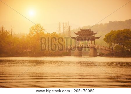 Traditional style pavilion and bridge at XiHu West Lake at sunset, Hangzhou, China