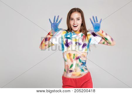 surprised  young woman is dirty in multicolored paint.