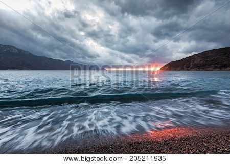 Sun Setting Under Storm Clouds At Bussaglia Beach In Corsica