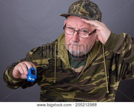 Senior Elderly Old Man Wearing Camouflage Clothing And Checking His Pulse And Oxygen Blood Levels Wi