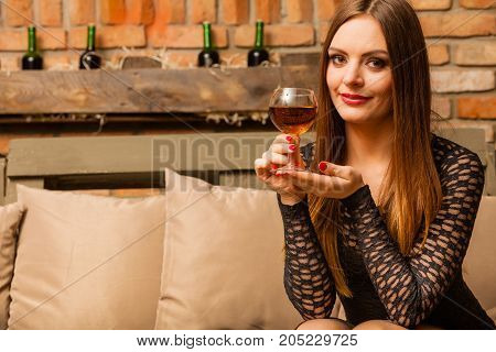 Woman Tasting Wine In Rural Cottage Interior