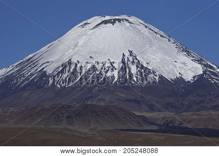 Ice covered peak of Volcano Parinacota in Lauca National Park high on the Altiplano of northern Chile.