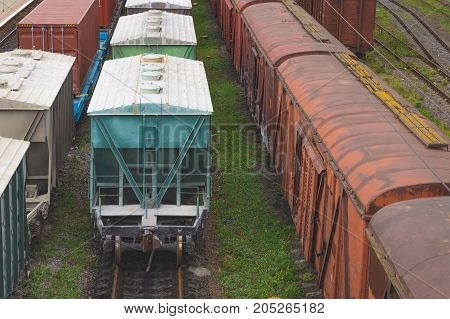 Old freight rail cars are on the track at the railway station