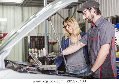 An auto mechanic and female customer in garage