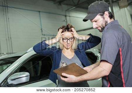 An auto mechanic and female customer in garage
