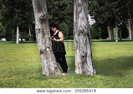 Woman talking on mobile phone in nature on a summer morning