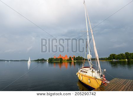 Trakai, Lithuania - August 15, 2017:Little yellow sport yacht on the lake Trakai, Lithuania. Beautiful summer landscape of Trakai lake in the stormy evening with Trakai Island Castle on background.