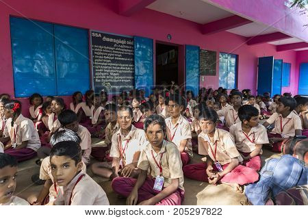 PONDICHERY PUDUCHERY INDIA - SEPTEMBER 04 2017. Outdoor meeting of the children of the school with uniforms sitting on the floor waiting for sport equipments as a gift from an association.