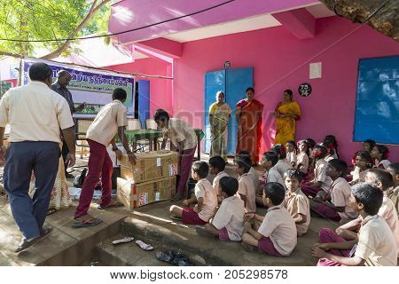 PONDICHERY PUDUCHERY INDIA - SEPTEMBER 04 2017. Outdoor meeting of the children of the school with uniforms sitting on the floor waiting for sport equipments as a gift from an association.