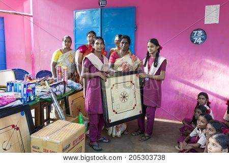 PONDICHERY PUDUCHERY INDIA - SEPTEMBER 04 2017. Outdoor meeting of the children of the school with uniforms sitting on the floor waiting for sport equipments as a gift from an association.