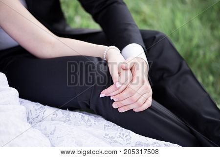Bride and groom holding hands outdoors on the grass