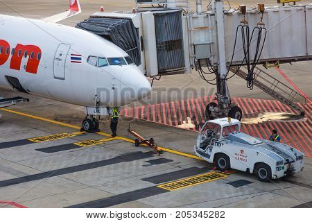 Bangkok Thailand - 14 September 2017 - Thai Lion Air aircraft waits for passengers while technician checks on the front wheel of the aircraft at Don Muang International Airport Bangkok Thailand on September 14 2017