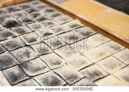 Preparation of Italian dish Ravioli. This is pasta from dough with different fillings. An analog of ravioli is dumplings. Kitchen background. National Food. Unprepared.